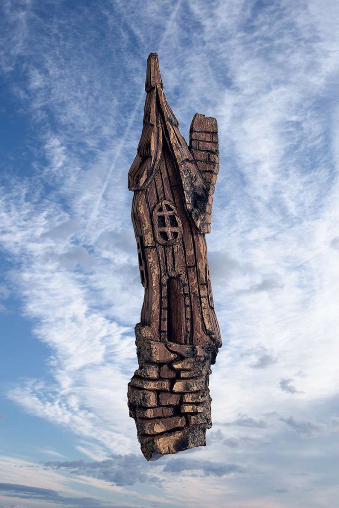 Wood carving of tall house