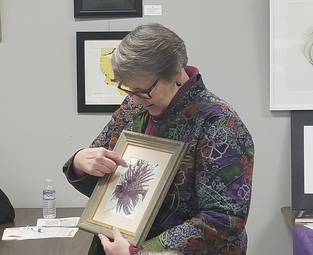 A woman points to a drawing of a fish