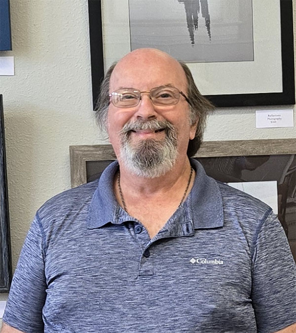 Man standing in front of photographs