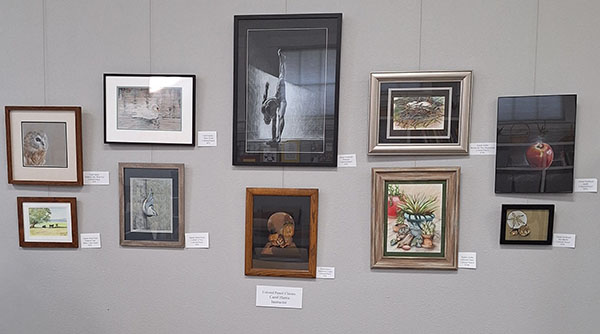 Several colored pencil drawings on a wall